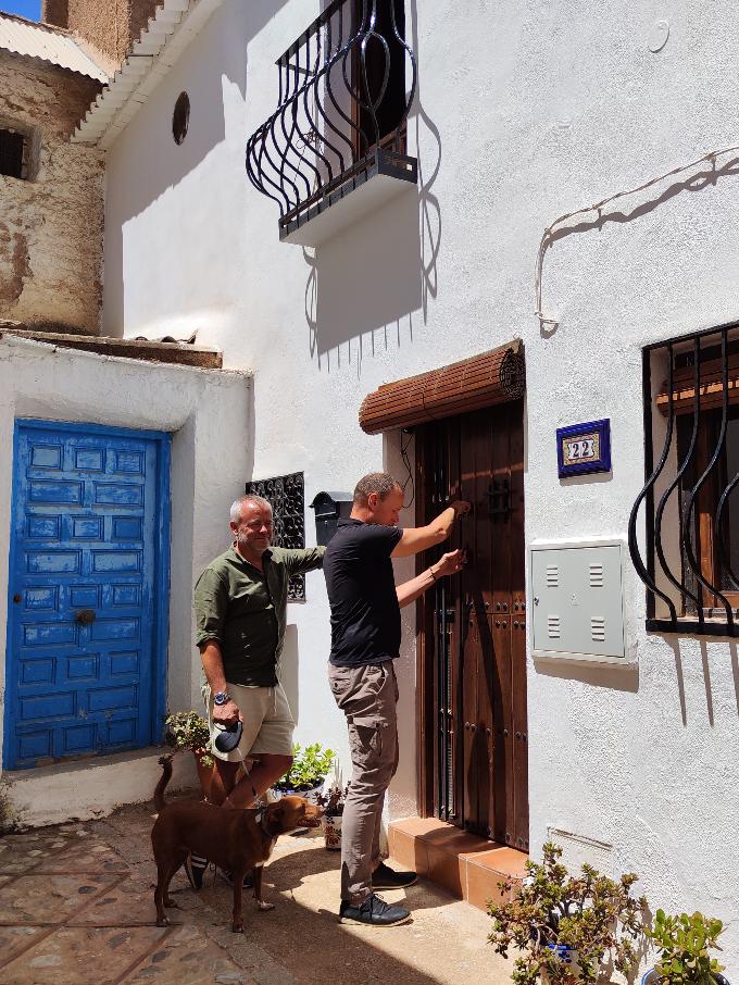 Johan en ik rollen de persiana's voor de ramen en de deuren van onze nieuwe Casita Lolapaluza voor het eerst omhoog